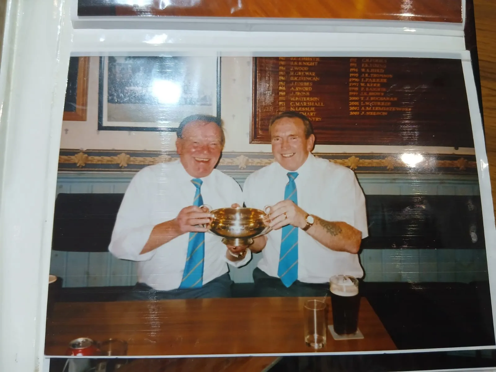 Two members with a trophy in the clubhouse, from the club archive
